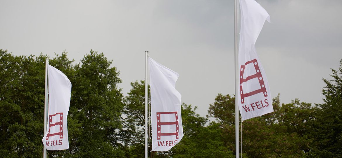 Flaggen mit Wolfgang Fels GmbH Logo als SInnbild für unsere Unternehmenshistorie