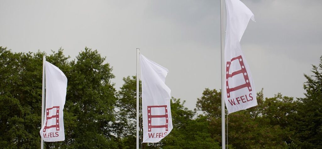 Flags with the Wolfgang Fels GmbH logo as a symbol of our company history
